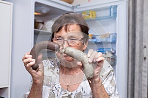 Senior woman holding pork liver sausages