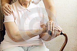 Close up of mature womans & nurse hands. Health care giving, nursing home. Parental love of grandmother. Old age related diseases.