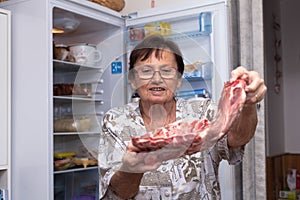 Senior woman holding raw pork ribs