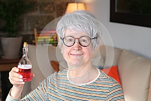 Senior woman holding red concoction