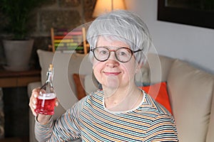 Senior woman holding red concoction