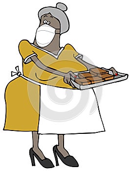 Senior woman holding a tray of brownies while wearing a face mask