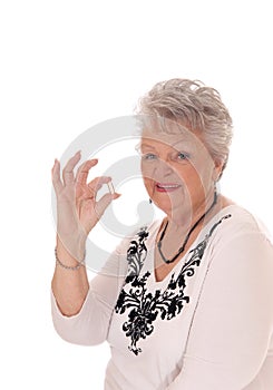 Senior woman holding vitamin pill.