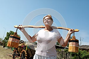 Senior woman holding wooden yoke