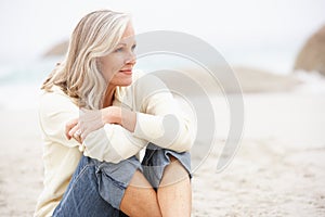 Senior Woman On Holiday Sitting On Beach