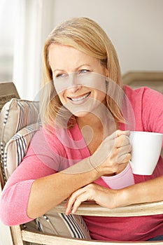 Senior woman at home with a drink