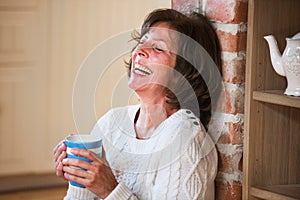 Senior woman at home enjoying hot drink.