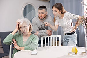 Senior woman ignoring adult couple scolding her