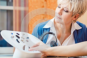 Senior woman with impairment choosing hearing aid photo