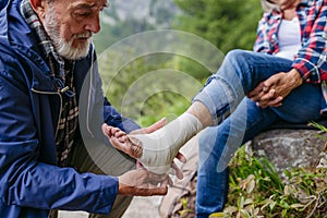 Senior woman injured her ankle during hike in the mountains.