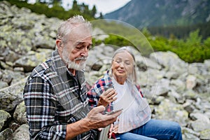 Senior woman injured her arm during hike in the mountains.