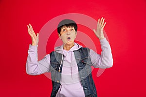 Senior woman isolated on red background. Tech and joyful elderly lifestyle concept