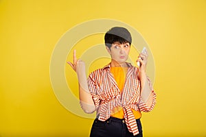 Senior woman isolated on yellow background. Tech and joyful elderly lifestyle concept