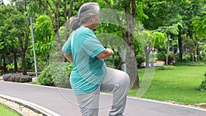 Senior woman jogging in outdoor stadium. Elderly female person is happy about cardio for health and wellness while walking or