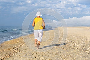Senior woman jogging on sea beach