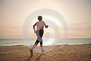 Senior woman jogging on sea beach