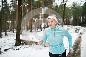 Senior woman jogging in winter nature.