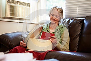 Senior Woman Keeping Warm Under Blanket With Memory Box