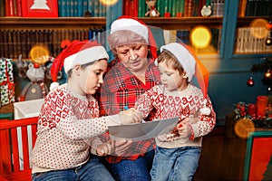 Senior woman with kids painting. Granny spending time with grandsons