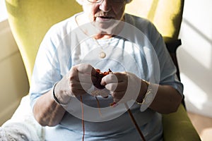 Senior woman knitting for hobby at home