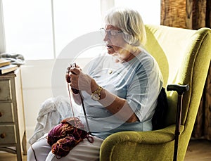 Senior woman knitting for hobby at home