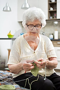 Senior woman knitting at home