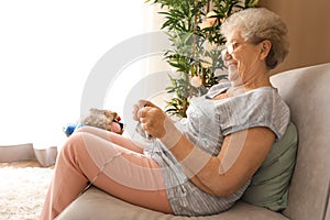 Senior woman knitting warm scarf at home