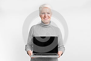 Senior woman with laptop and blank screen