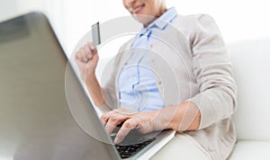 Senior woman with laptop and credit card at home