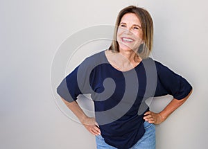 Senior woman laughing against gray background