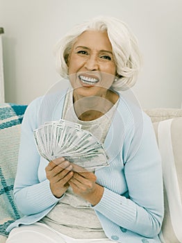 Senior Woman Laughs Holding A Fan Of Money