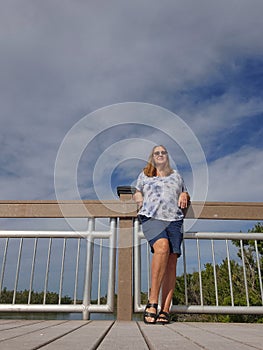 Senior Woman Leaning Against a Bridge Railing in Florida