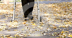 Senior woman legs walking with walker in autumn park