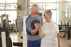 Senior woman lifting weights with her husband.