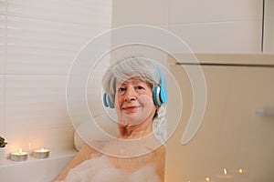 Senior woman listening to music in the bathtub