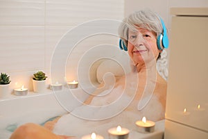Senior woman listening to music in the bathtub