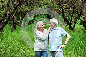 Senior woman looking at husband standing with hand on hip