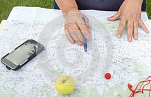 Senior woman looking at a map of Barcelona preparing for a trip, tourism in Europe