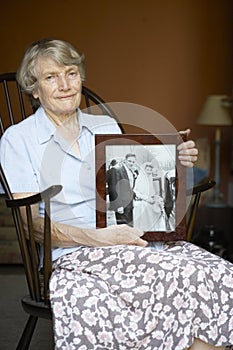Senior Woman Looking At Old Wedding Photo