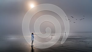 Senior Woman looking out into the Dense Fog over the Pacific Ocean in Cox Bay