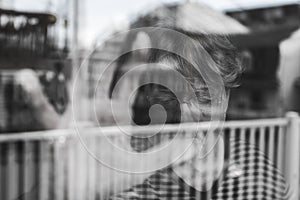 Senior woman looking out through a window like depress