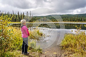 Senior woman looking over Little McGillivray Lake