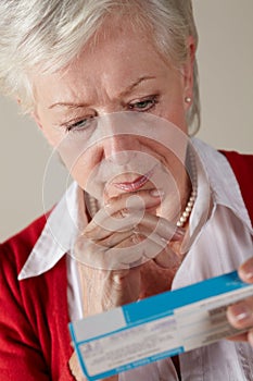 Senior woman looking at prescription drug pack