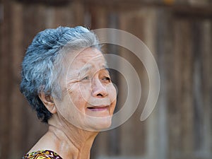 Senior woman looking up with a smile while standing outdoors