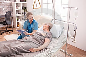 Senior woman lying in nursing home bed