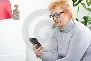 Senior woman making phone call at home. Portrait beautiful of smiling mature female talking on smartphone, relaxing