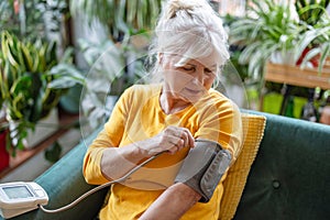 Senior woman measuring her blood pressure