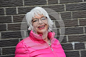Senior woman with modish  pink duvet jacket photo
