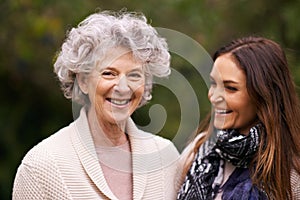 Senior woman, mother and face with daughter for love, bonding and visit from child outdoor in backyard, garden and patio