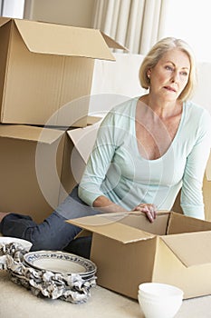 Senior Woman Moving Home And Packing Boxes